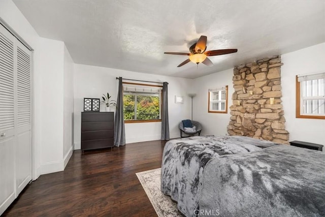 bedroom featuring a closet, a ceiling fan, baseboards, and wood finished floors
