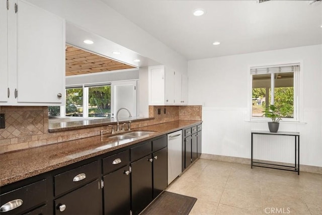 kitchen featuring a sink, white cabinets, stainless steel dishwasher, and a wealth of natural light
