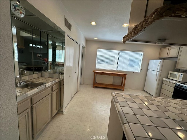18405C Collins St Unit C, Tarzana, CA 91356 - kitchen with tile counters, white appliances, recessed lighting, and light floors
