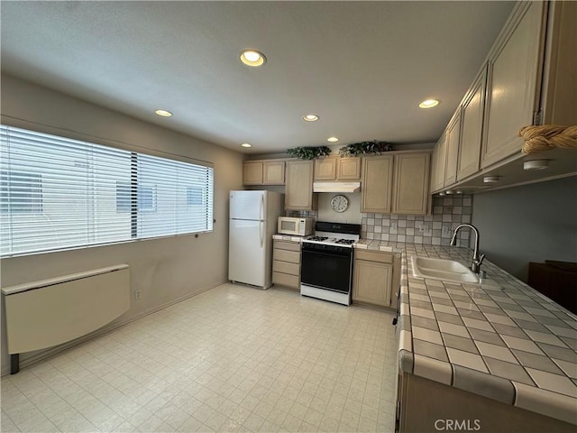 18405C Collins St Unit C, Tarzana, CA 91356 - kitchen with white appliances, tile counters, under cabinet range hood, backsplash, and recessed lighting