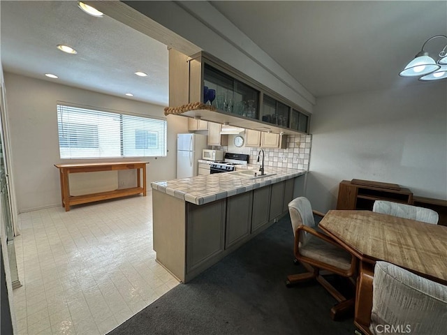 18405C Collins St Unit C, Tarzana, CA 91356 - kitchen featuring white appliances, tile countertops, a peninsula, decorative backsplash, and recessed lighting