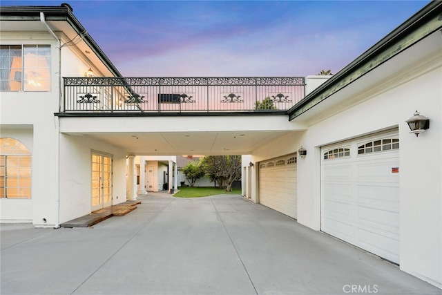 garage at dusk with french doors and driveway