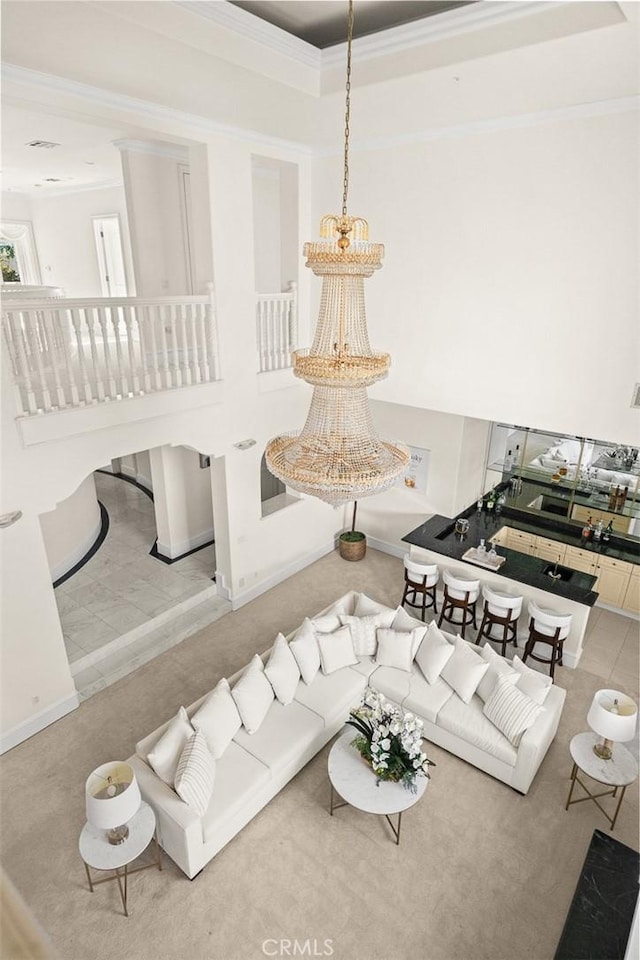 carpeted living area with baseboards and ornamental molding