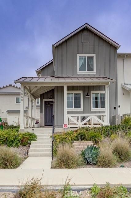 bungalow featuring board and batten siding, a standing seam roof, metal roof, and covered porch