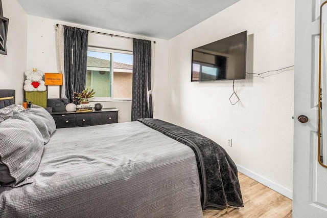 bedroom with wood finished floors and baseboards