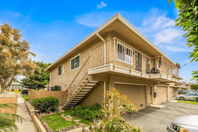 view of home's exterior with stucco siding, an attached garage, and stairs