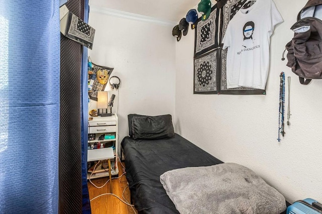 bedroom featuring wood finished floors and crown molding