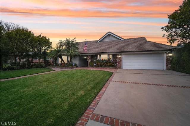 view of front of home with brick siding, a front lawn, driveway, and an attached garage