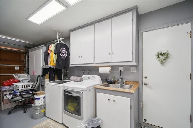 laundry room with a sink, cabinet space, and washer and clothes dryer