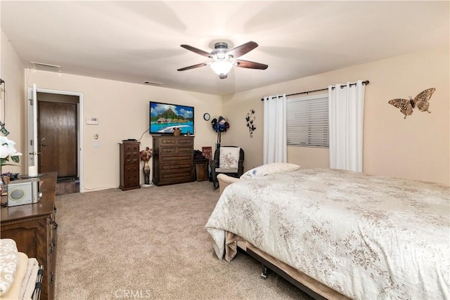 bedroom featuring visible vents, light colored carpet, and ceiling fan