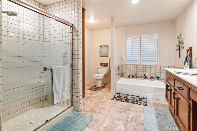 full bathroom featuring toilet, a garden tub, vanity, and a stall shower