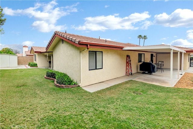 back of house featuring stucco siding, fence, a patio, and a lawn