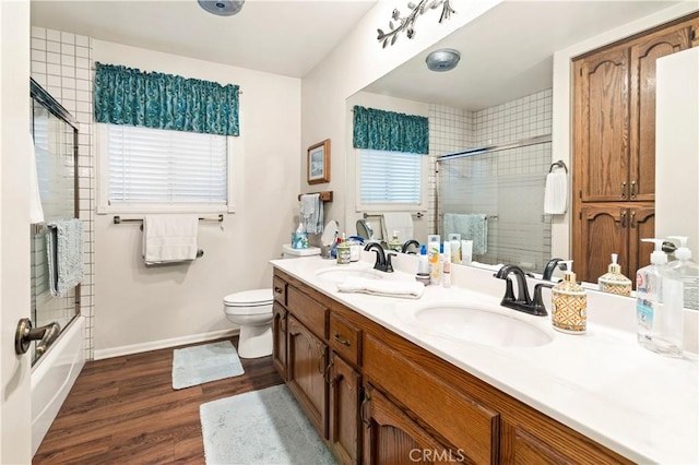 full bathroom featuring wood finished floors, baseboards, a sink, and double vanity