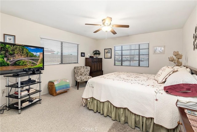 carpeted bedroom with a ceiling fan and multiple windows