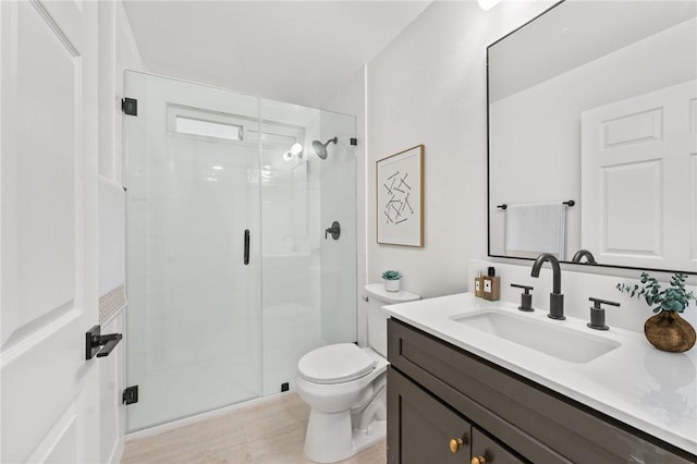 full bathroom with toilet, vanity, and a stall shower