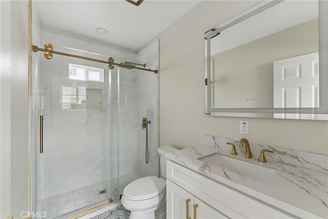 bathroom with toilet, vanity, and a marble finish shower