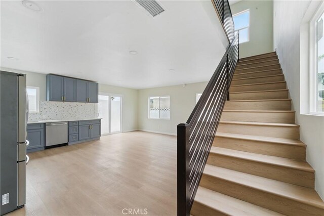 staircase with wood finished floors and visible vents