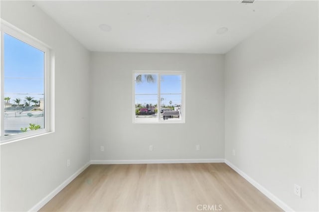 spare room featuring light wood-type flooring and baseboards