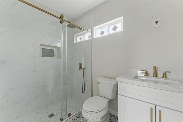 bathroom with a marble finish shower, vanity, and toilet