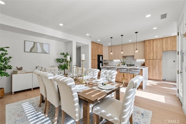 dining area with recessed lighting, light wood-style flooring, and visible vents