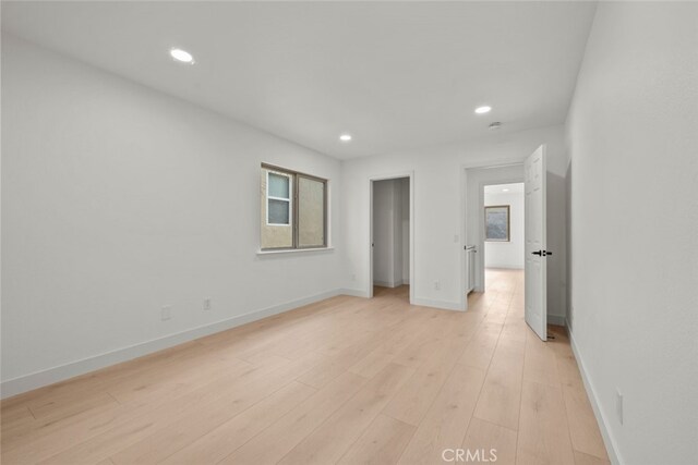 unfurnished bedroom featuring light wood-style flooring, baseboards, and recessed lighting