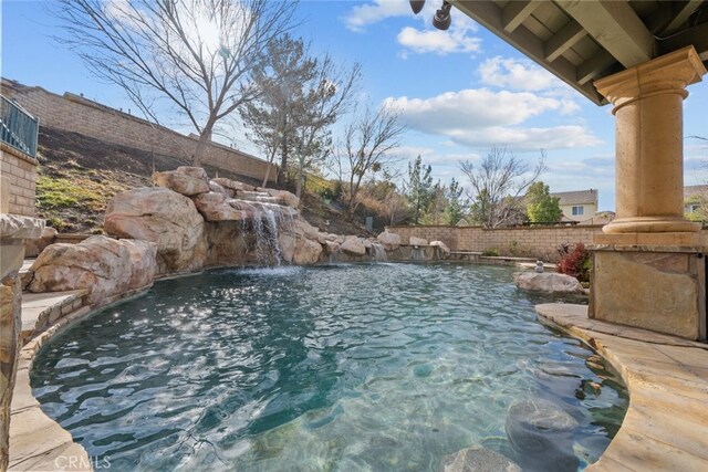 view of swimming pool featuring fence