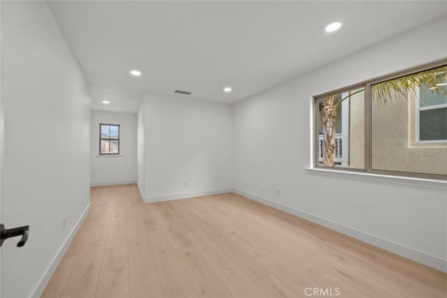 empty room featuring baseboards, visible vents, and recessed lighting