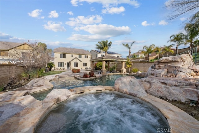 outdoor pool featuring a gazebo, fence, a patio, and an in ground hot tub