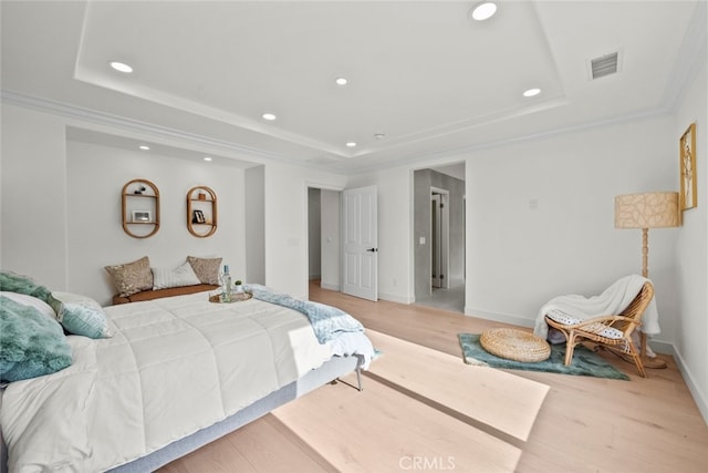 bedroom with recessed lighting, light wood-style flooring, visible vents, and a raised ceiling