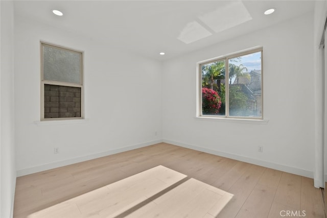 unfurnished room with recessed lighting, wood finished floors, and baseboards