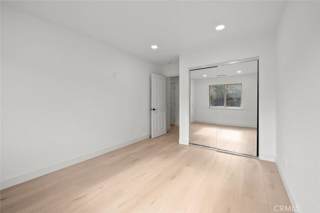 unfurnished bedroom featuring recessed lighting, light wood-style floors, a closet, and baseboards