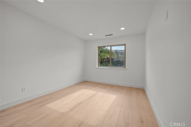 spare room featuring recessed lighting, wood finished floors, visible vents, and baseboards