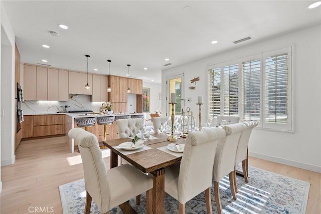 dining space featuring baseboards, light wood-style flooring, visible vents, and recessed lighting