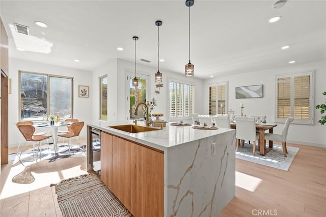 kitchen featuring light wood-style floors, a sink, recessed lighting, and a healthy amount of sunlight