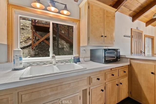 interior space featuring light brown cabinets, a sink, and tile counters