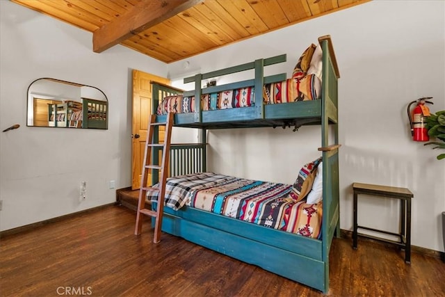 bedroom with beamed ceiling, wood finished floors, baseboards, and wooden ceiling