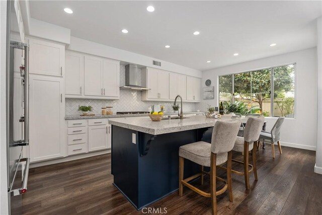 1 Giverny, Newport Coast, CA 92657 - kitchen with wall chimney range hood, recessed lighting, tasteful backsplash, white cabinetry, and a breakfast bar