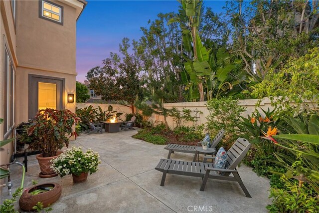 1 Giverny, Newport Coast, CA 92657 - patio terrace at dusk with an outdoor fire pit, a patio area, and a fenced backyard