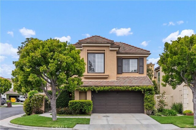 1 Giverny, Newport Coast, CA 92657 - view of front of house with stucco siding, an attached garage, concrete driveway, and a tiled roof