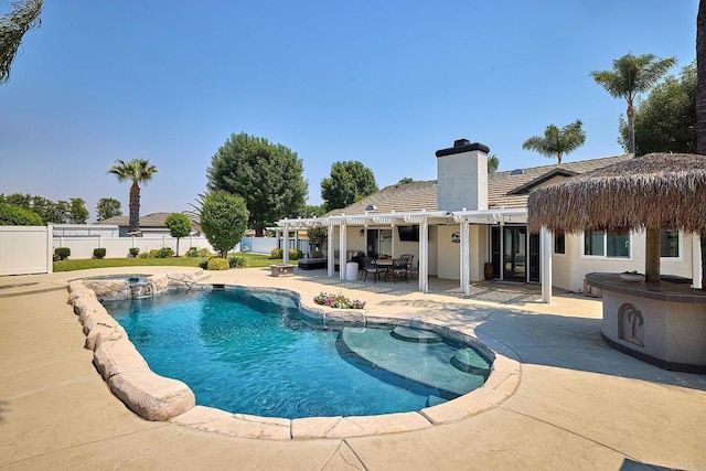 view of pool featuring a pergola, a pool with connected hot tub, a patio, and fence
