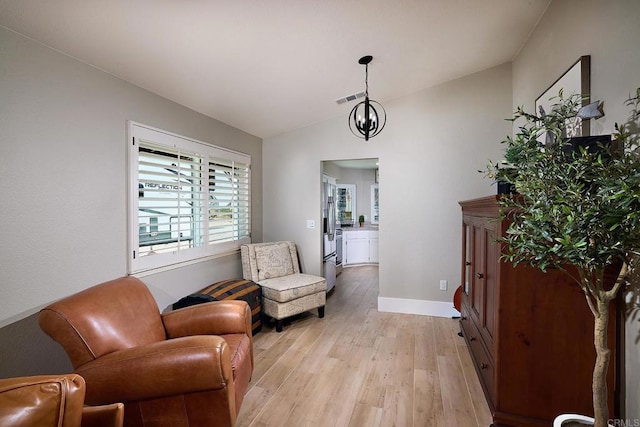 sitting room featuring lofted ceiling, visible vents, baseboards, and light wood-type flooring