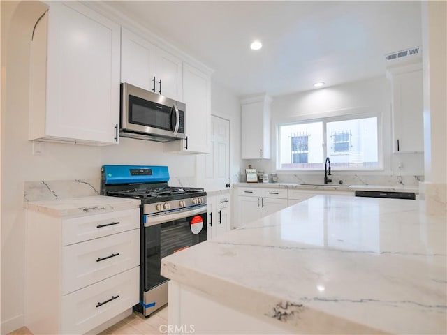 1954 W 71st, Los Angeles, CA 90047 - kitchen featuring appliances with stainless steel finishes, a sink, light stone countertops, white cabinetry, and recessed lighting