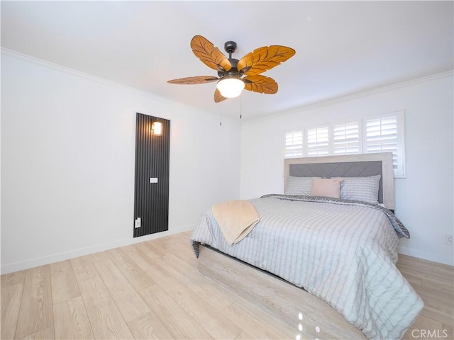 bedroom with wood finished floors, ornamental molding, and baseboards