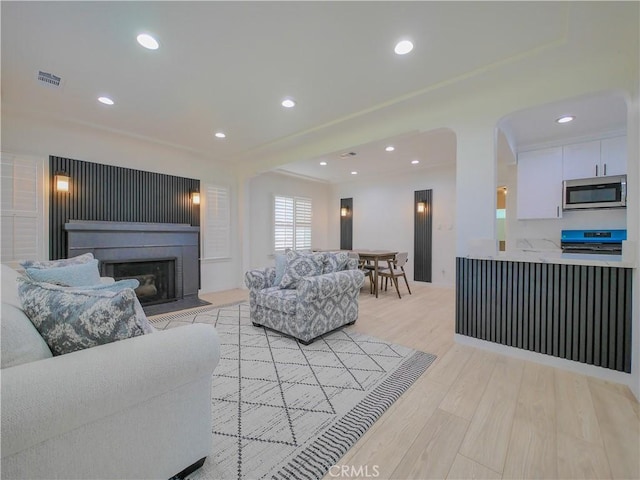 1954 W 71st, Los Angeles, CA 90047 - living area featuring a fireplace with flush hearth, light wood-style flooring, recessed lighting, and arched walkways