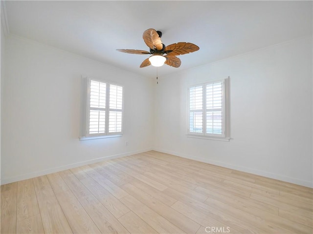 spare room with baseboards, light wood-type flooring, and ceiling fan