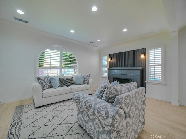 living room featuring a fireplace, visible vents, and a healthy amount of sunlight