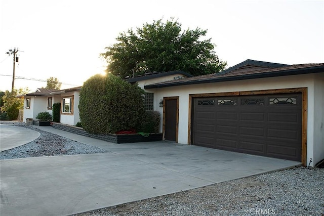 view of front of property with driveway, stucco siding, and a garage