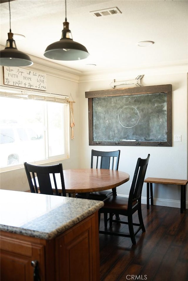 dining area with ornamental molding, dark wood-style floors, and visible vents