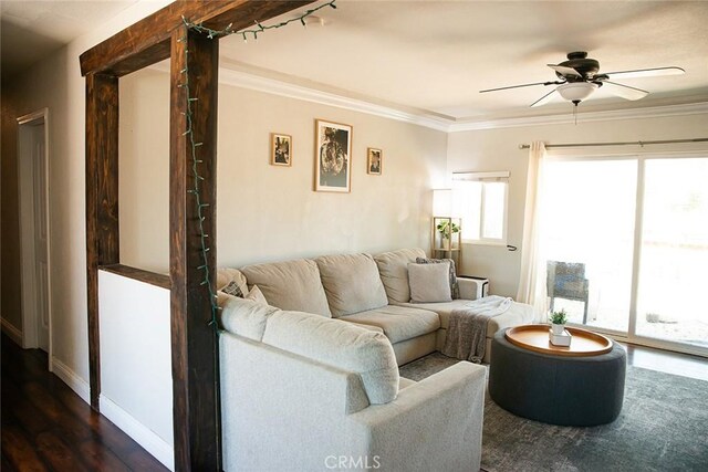 living area featuring baseboards, ornamental molding, ceiling fan, and dark wood-style flooring