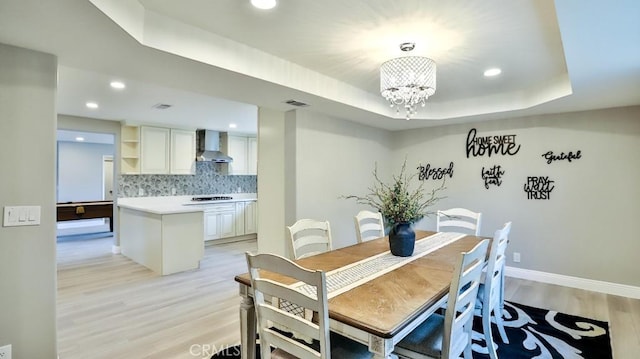 18971 Birch St, Perris, CA 92570 - dining area featuring light wood-style flooring, a chandelier, recessed lighting, a tray ceiling, and baseboards